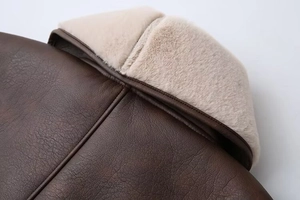 Detail of dark brown faux leather jacket collar with soft cream sherpa lining texture