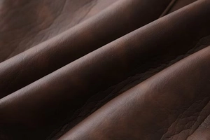 Macro shot of dark mocha leather texture with natural grain for warm winter coats