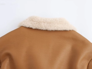 Détail d'une veste en simili cuir marron avec col en fausse fourrure crème duveteuse