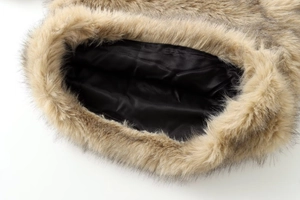 Detail of fluffy brown faux fur collar and smooth black satin lining of the pullover jacket