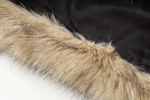 Macro detail of high-quality black fabric stitched with plush faux fur collar trim