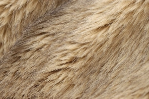Close-up of fluffy faux fur texture in tan and brown shades with soft high-pile layers