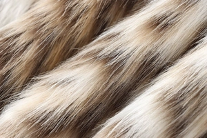 Close-up of smooth leopard print faux fur texture with glossy brown and beige fibers