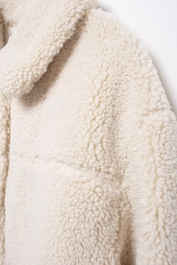 Detailed close-up of cream fleece jacket collar showing premium shearling texture