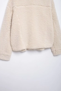 Close-up of off-white sherpa fleece jacket texture with premium stitching details