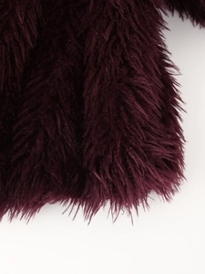 Nahaufnahme der flauschigen burgunderroten Kunstpelz-Struktur einer Winterjacke