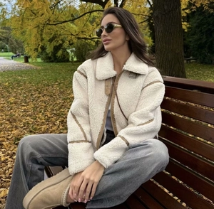 Sherpa fleece jacket with brown leather trim detailing in an autumn park setting