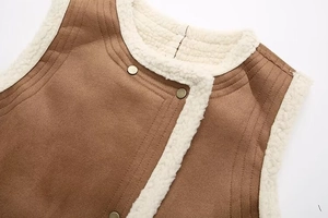 Close-up of brown faux suede vest with soft white sherpa fleece lining and metal buttons