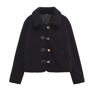 Close-up detail of black teddy fleece texture and decorative metal buckle closures