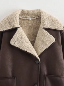 Close-up of brown faux suede jacket featuring white shearling lining and S size tag