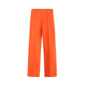 Macro detail of bright orange high-waisted wide-leg trousers with elegant front pleat