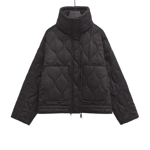 Détail de la veste matelassée noire avec col montant et grandes poches plaquées