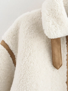Detailed close-up of cream sherpa fabric with brown faux suede trim and soft texture