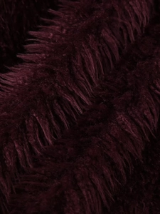 Dettaglio della morbida pelliccia sintetica bordeaux sul colletto del cappotto corto