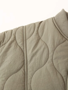 Gros plan sur la veste matelassée vert olive avec surpiqûres vagues et col côtelé
