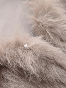 Dettaglio della texture in morbida pelliccia sintetica marrone chiaro per gilet invernali