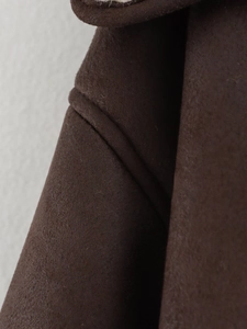 Close-up of deep brown faux shearling fabric showing high-quality stitching and texture