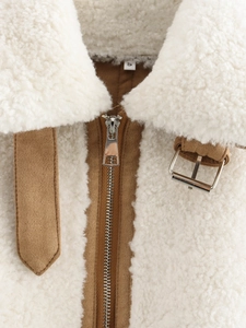 Detail of faux shearling jacket with white borg fabric, brown suede trim, and metal zipper
