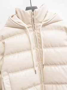 Detail of cream PU leather hooded jacket featuring horizontal quilting and silver metal zipper