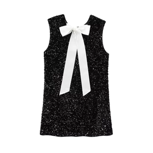 Detailed view of women's sequin mini dress with a large white satin bow on the back