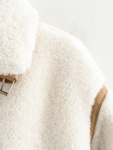 Detail of faux shearling jacket featuring brown leather collar buckles and soft wool texture
