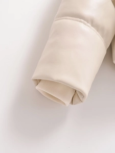 Detail of ribbed knit windproof cuffs on a cream faux leather hooded puffer jacket