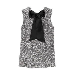 Detail of silver sequin party dress featuring a large decorative black bow on the back
