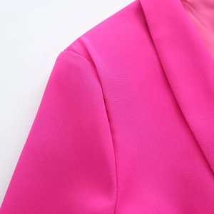 Close-up of hot pink blazer featuring notched lapels and high-density woven fabric detail