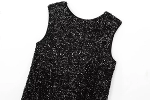 Detail of shimmering black sequins on sleeveless party dress with metallic reflection
