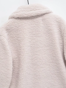 Detail of premium beige sherpa fleece jacket texture and collar on black hanger