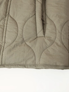 Vue détaillée du tissu matelassé olive avec motif oignon et texture en nylon