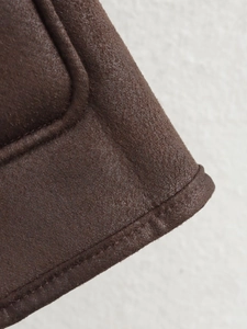 Detailed macro shot of dark brown faux suede fabric with precise stitching craftsmanship
