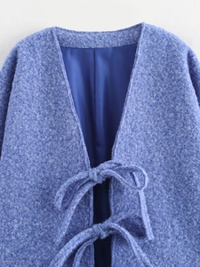 Dettaglio del cardigan in lana blu con chiusure a fiocco e fodera in seta lucida