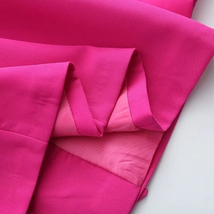 Close-up of fuchsia blazer woven fabric with smooth matching lining and fine stitching
