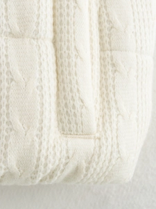 Dettaglio macro della trama a treccia e cuciture di alta qualità del gilet da donna