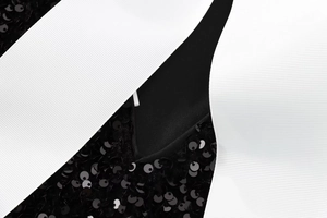 Close-up of black sequins and white grosgrain ribbon detail on the party mini dress