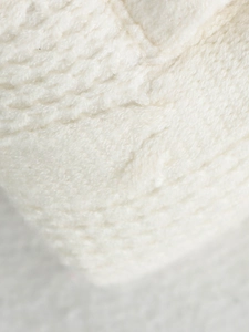 Front view of stylish white knitted patchwork puffer jacket with soft stand collar