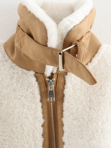 Detail of faux shearling collar with adjustable metal buckle and textured zip closure