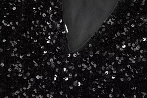 Detailed close-up of V-neckline with black sequins on a luxury party mini dress