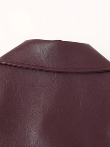 Detailed macro shot of dark burgundy faux leather texture and precise stitching on the jacket