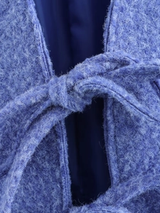 Dettaglio della cintura a fiocco sul cardigan in lana blu testurizzata da donna