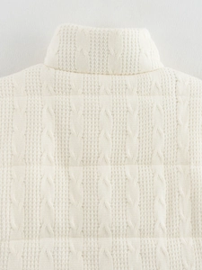 Dettaglio gilet trapuntato bianco crema in maglia a trecce con collo alto e trama morbida