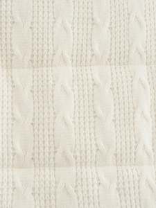 Vista macro dettagliata della trama a treccia bianco crema su un gilet alla moda