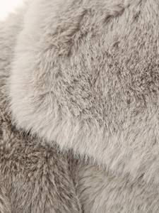 Close-up of the plush faux fur texture on a grey winter coat with soft fluffy fibers