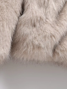 Close-up of thick beige faux fur texture showing soft fluffy fibers and luxurious material