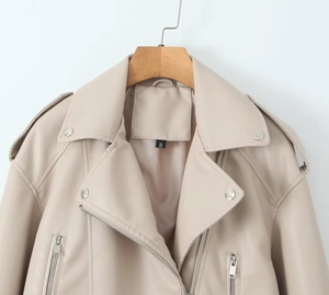 Détail du blouson biker en similicuir crème avec large col et fermetures éclair
