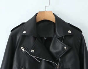 Close-up of black PU leather biker jacket featuring silver zippers and size S label