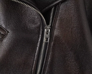 Gros plan sur la texture du cuir premium et le détail du zip en métal argenté robuste