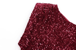 Detailed view of burgundy velvet fabric with densely sewn sequins for evening party dress
