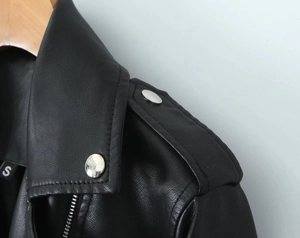 Detailed macro shot of motorcycle jacket collar with silver metal snaps and zipper texture